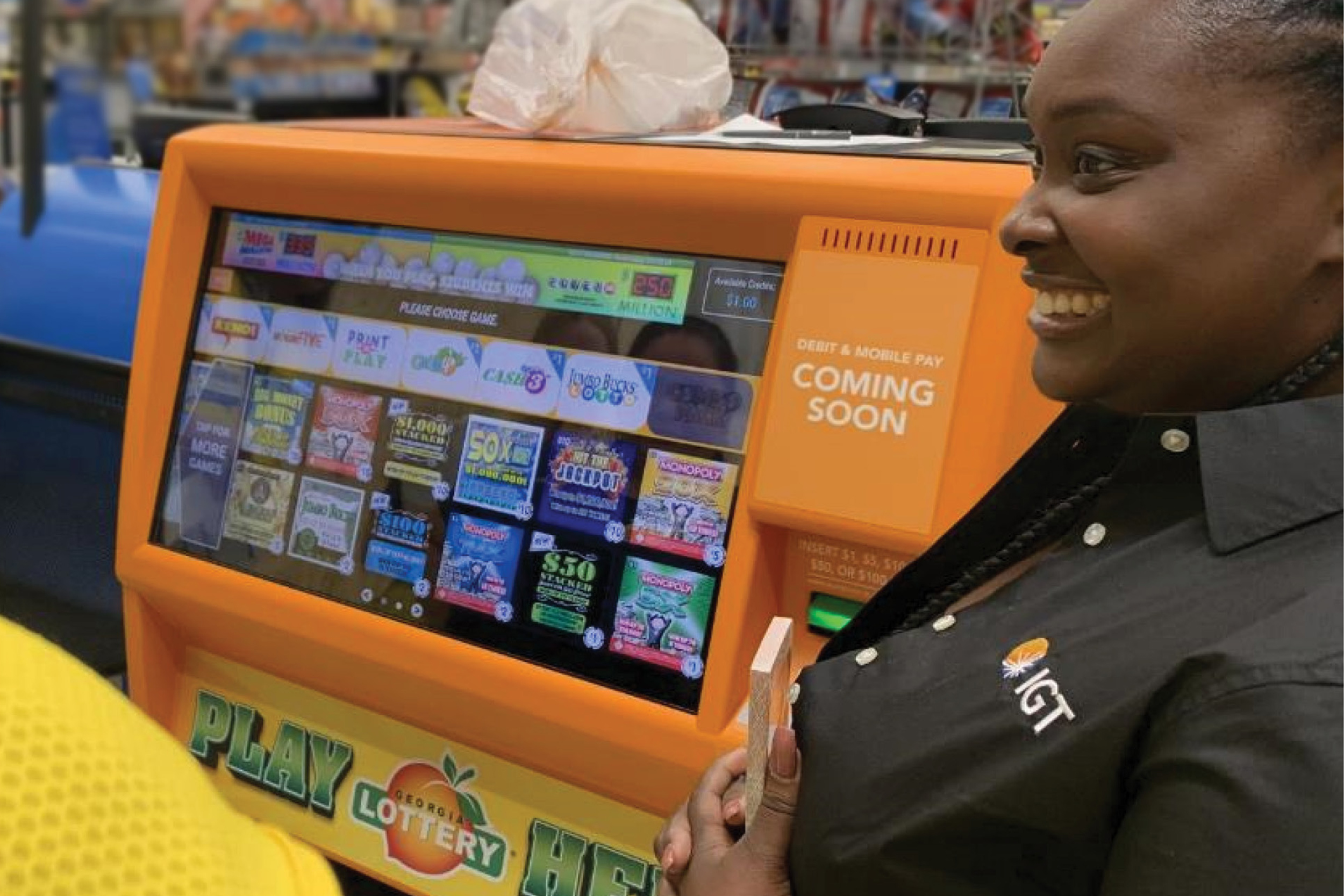 A sales representatives stands in front of an orange instant ticket vending machine