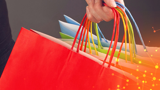 A hand holding multicolored gift bags with IGT Advantage Icons. 