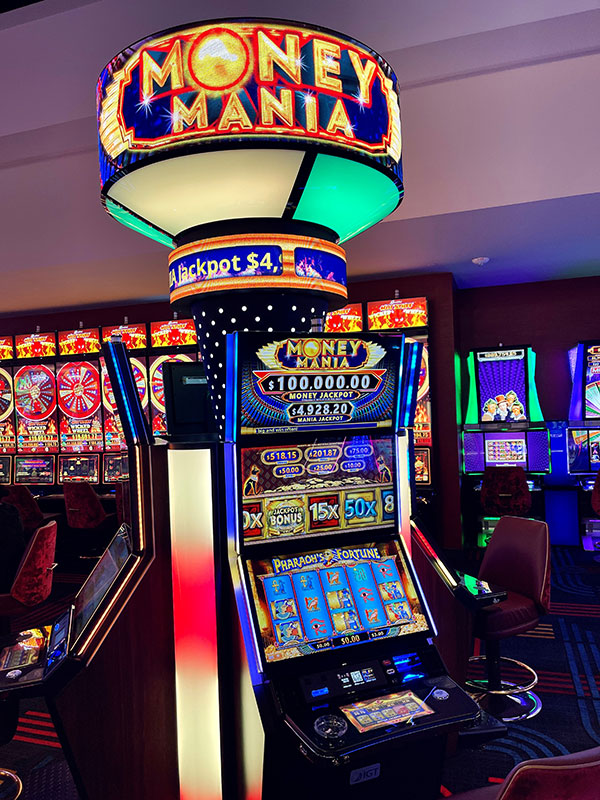 Three Money Mania wide area progressive slot machines on a casino floor