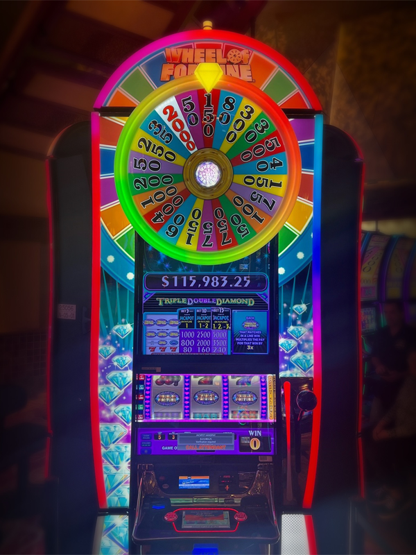 A Jackpot winner notification for $115,983 on IGT'S Wheel of Fortune Triple Double Diamond Wide Area Progressive slot games.