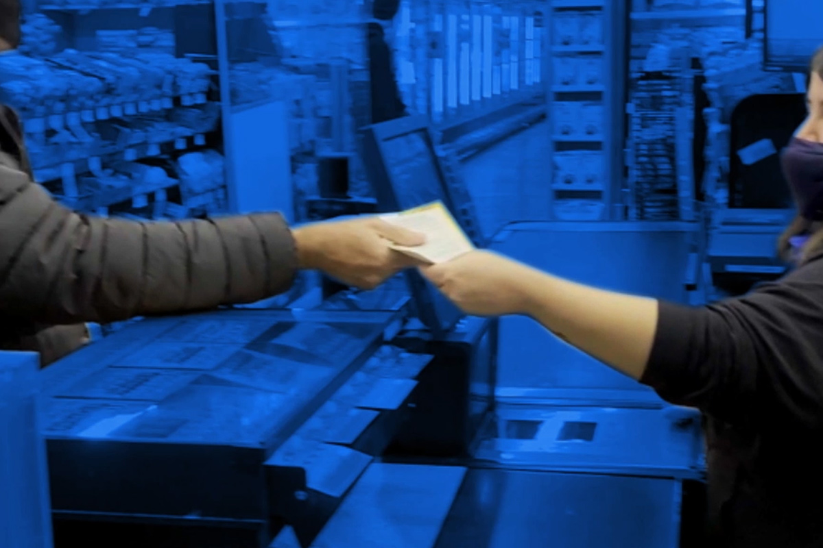 Blue background with a cashier handing a customer an instant ticket and receipt